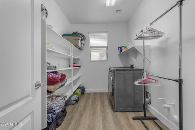 laundry area with washer and dryer and light wood-type flooring