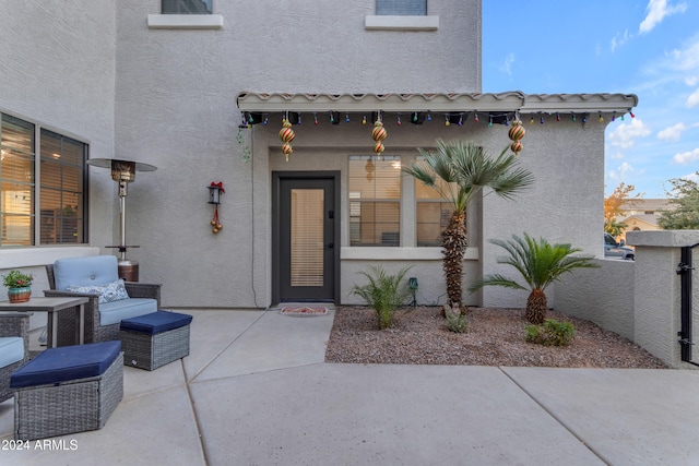 entrance to property with an outdoor living space and a patio