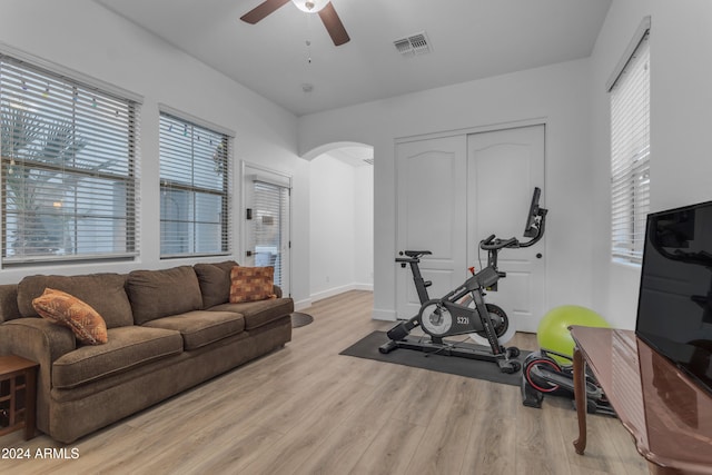 exercise room with ceiling fan and light hardwood / wood-style flooring