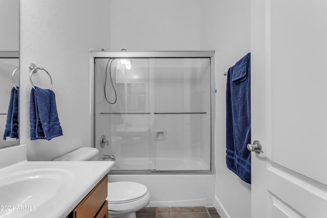 full bathroom featuring enclosed tub / shower combo, vanity, toilet, and tile patterned flooring