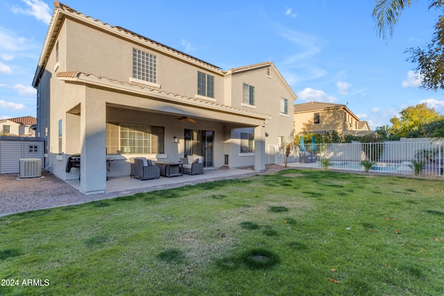 back of house with central AC, ceiling fan, a patio area, and a lawn