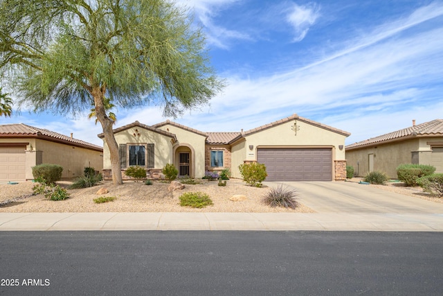 mediterranean / spanish home with a garage, driveway, a tiled roof, and stucco siding