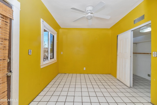 spare room featuring a ceiling fan, visible vents, and light tile patterned floors