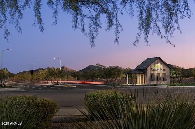 exterior space featuring street lights, curbs, and a mountain view