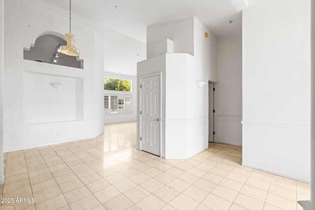 tiled spare room featuring a high ceiling