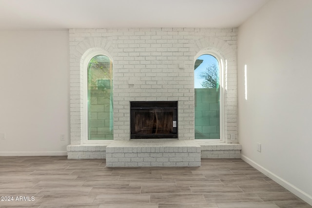 unfurnished living room with light wood-type flooring and a fireplace