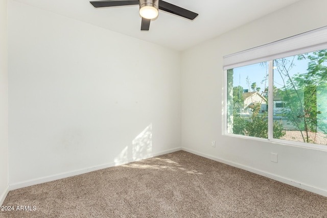 carpeted spare room featuring ceiling fan