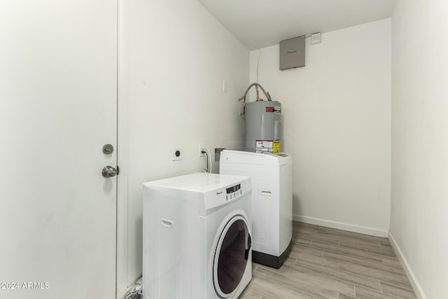 laundry area featuring washer and dryer, light hardwood / wood-style flooring, and electric water heater