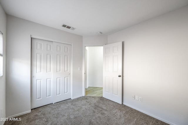 unfurnished bedroom featuring carpet flooring and a closet