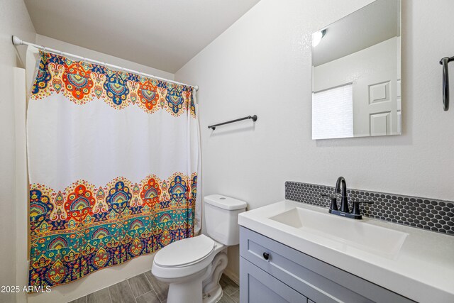 bathroom featuring tasteful backsplash, vanity, and toilet