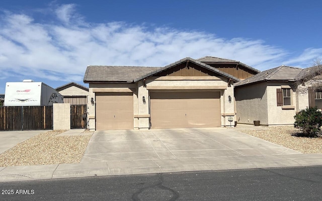 view of front of property featuring a gate, an attached garage, stucco siding, concrete driveway, and a tile roof