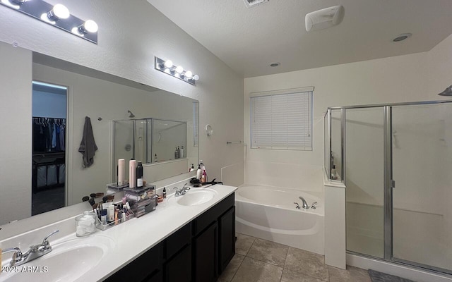 bathroom with tile patterned flooring, a shower stall, a garden tub, and a sink