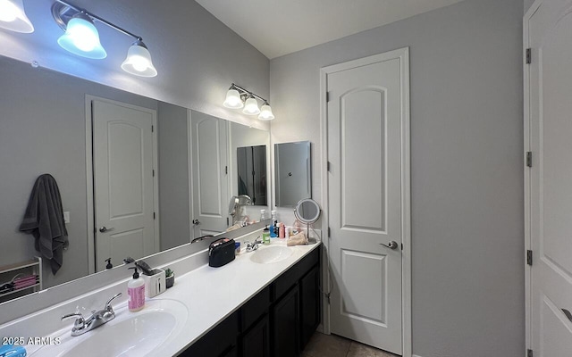 bathroom featuring tile patterned flooring, double vanity, and a sink