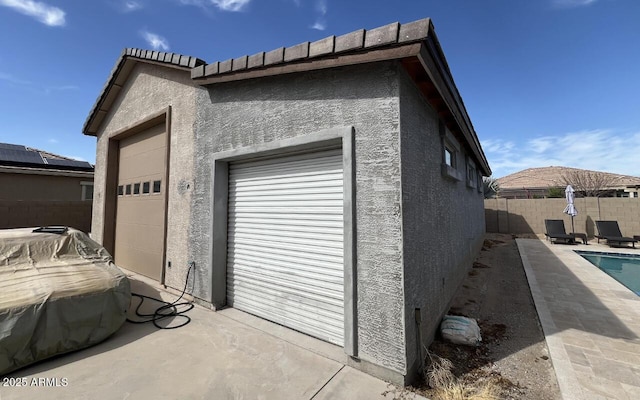 garage with a fenced in pool and fence