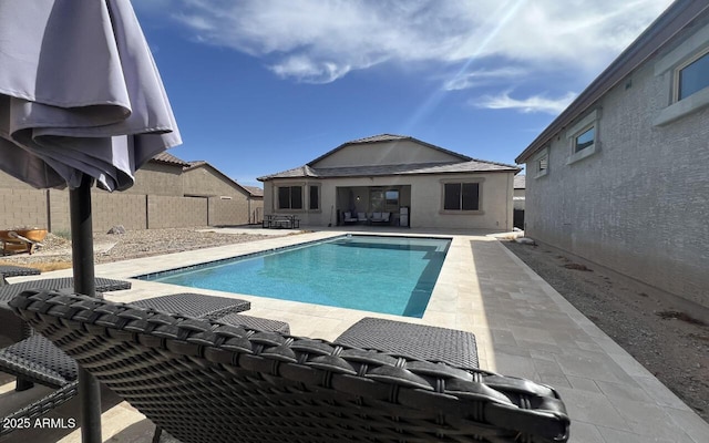 view of swimming pool with an outdoor structure, a fenced in pool, a patio area, and fence