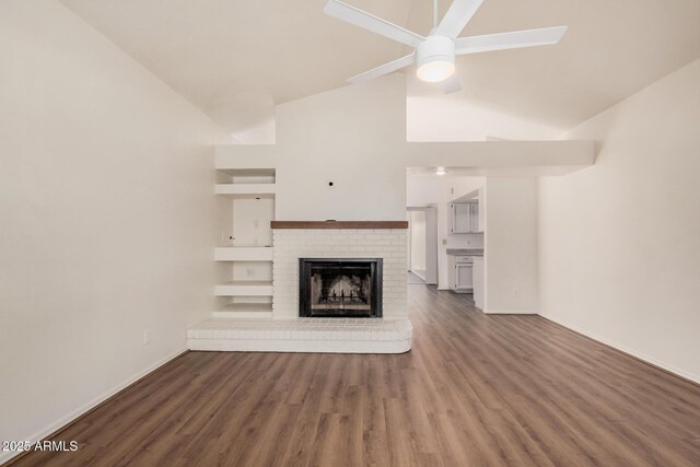 927 E Charleston Ave, Phoenix, AZ 85022 - unfurnished living room featuring high vaulted ceiling, a brick fireplace, wood finished floors, baseboards, and ceiling fan