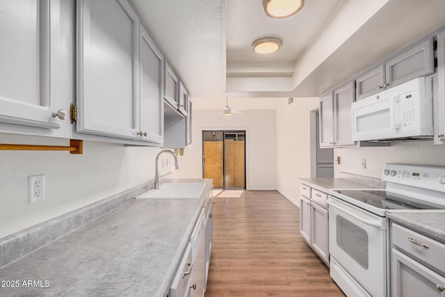 927 E Charleston Ave, Phoenix, AZ 85022 - kitchen featuring white appliances, a sink, a tray ceiling, gray cabinetry, and a ceiling fan