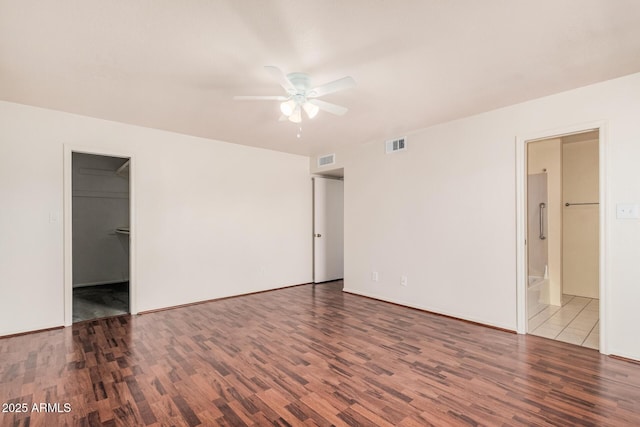 927 E Charleston Ave, Phoenix, AZ 85022 - unfurnished bedroom with wood finished floors, a spacious closet, connected bathroom, and a ceiling fan
