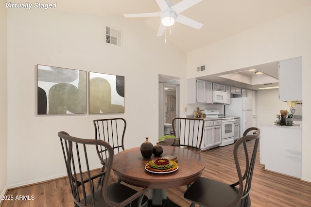 927 E Charleston Ave, Phoenix, AZ 85022 - dining room featuring wood finished floors, a ceiling fan, baseboards, a high ceiling, and a raised ceiling