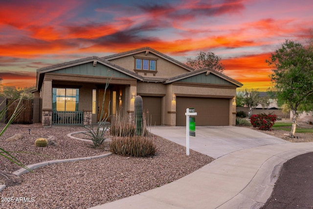 12702 W Dove Wing Way, Peoria, AZ 85383 - view of front of home with stone siding, a garage, stucco siding, a porch, and driveway