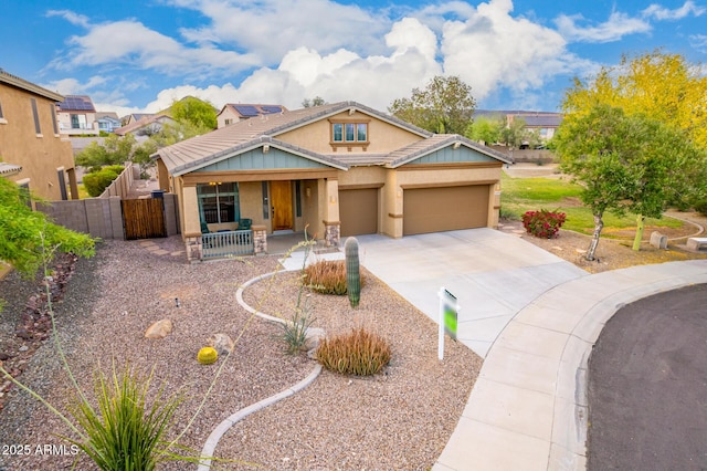 12702 W Dove Wing Way, Peoria, AZ 85383 - view of front of home featuring a porch, driveway, fence, an attached garage, and stucco siding