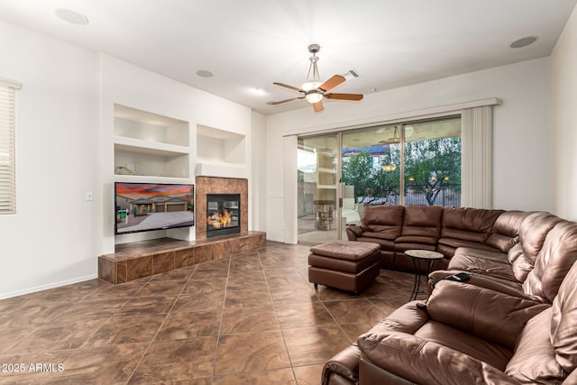 12702 W Dove Wing Way, Peoria, AZ 85383 - living area with baseboards, ceiling fan, built in features, and a tiled fireplace