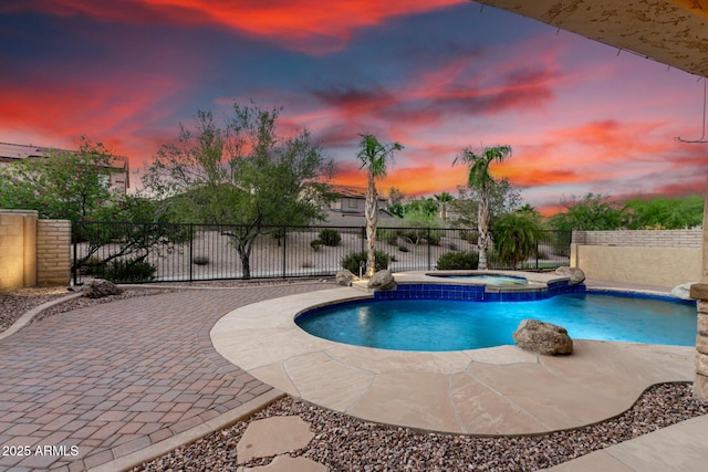 12702 W Dove Wing Way, Peoria, AZ 85383 - pool at dusk with an in ground hot tub, fence, a patio area, and a fenced in pool