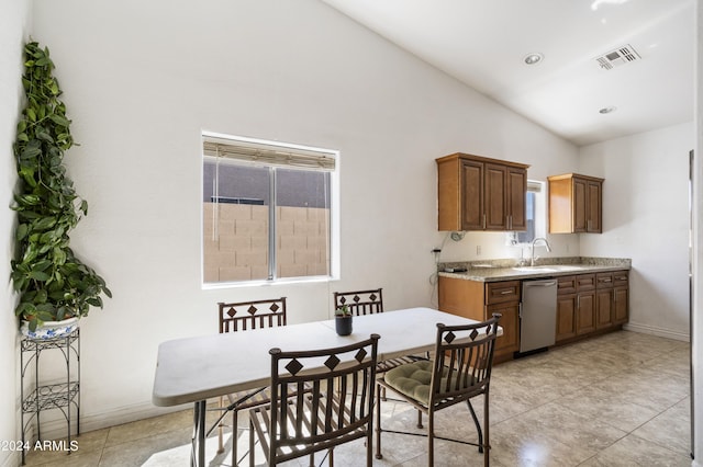 tiled dining room with vaulted ceiling and sink