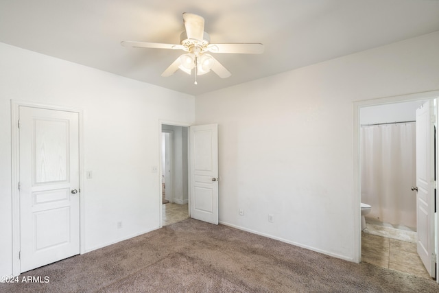 unfurnished bedroom with ceiling fan, light carpet, and connected bathroom