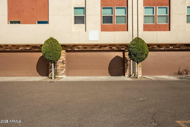 view of front facade featuring driveway, brick siding, and an attached garage