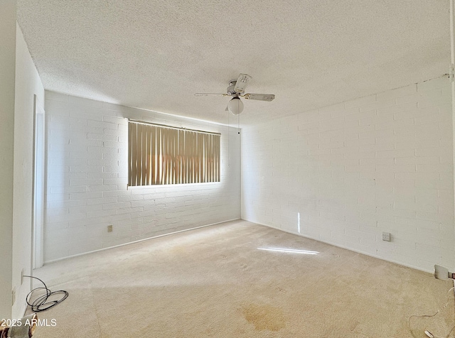 unfurnished room featuring brick wall, a textured ceiling, carpet, and ceiling fan