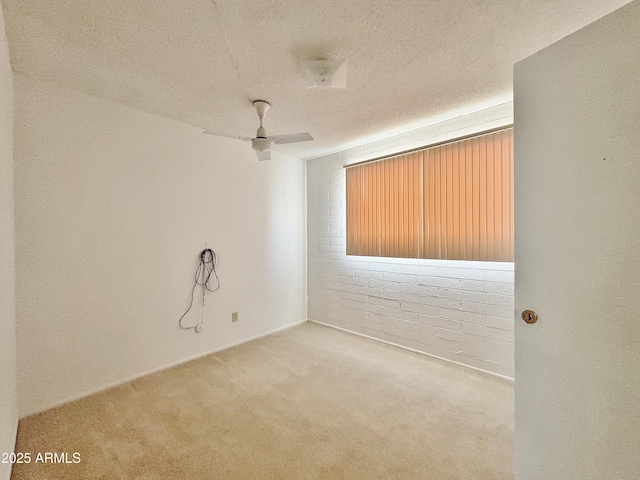 carpeted empty room featuring ceiling fan and a textured ceiling