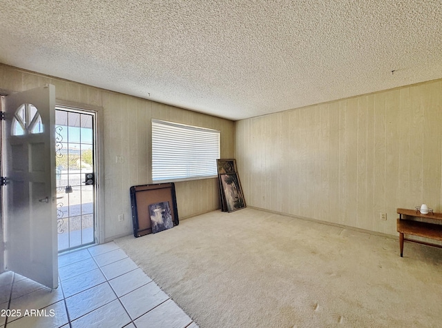 unfurnished living room with light tile patterned flooring and a textured ceiling