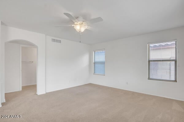 carpeted spare room featuring ceiling fan