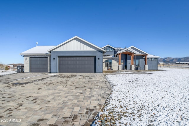 view of front facade with an attached garage, board and batten siding, and decorative driveway