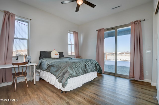 bedroom featuring access to exterior, visible vents, a ceiling fan, wood finished floors, and baseboards