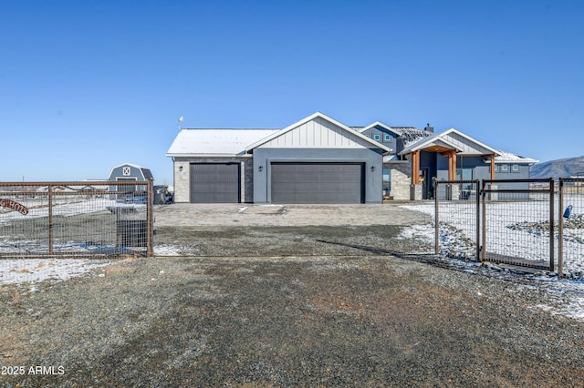 view of front of home featuring a garage, a gate, fence, and board and batten siding