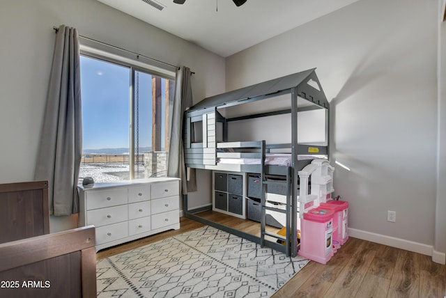 bedroom with wood finished floors, a ceiling fan, and baseboards