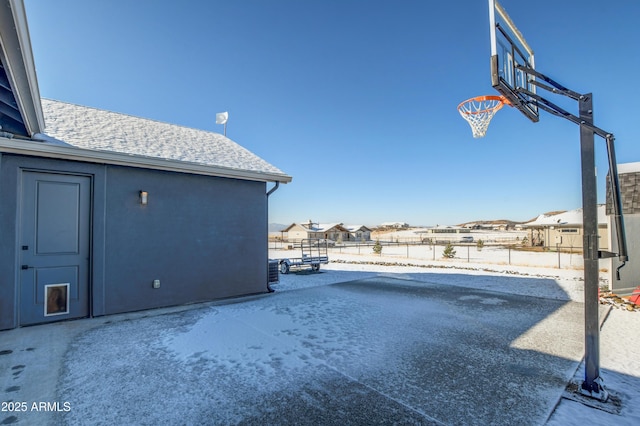 view of patio / terrace featuring basketball hoop, a residential view, and fence