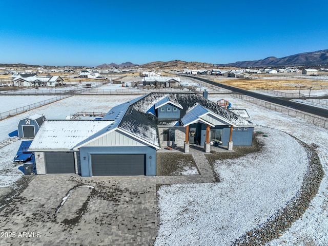 view of front of house featuring an attached garage, board and batten siding, a mountain view, and decorative driveway