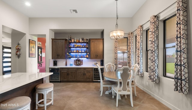 dining room with beverage cooler, finished concrete floors, baseboards, and visible vents