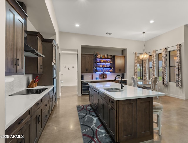 kitchen with a kitchen bar, a sink, wine cooler, light countertops, and black electric stovetop