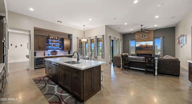 kitchen with beverage cooler, finished concrete floors, a sink, stainless steel dishwasher, and open floor plan