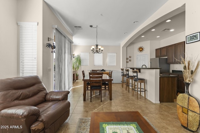 dining room with light tile patterned floors and an inviting chandelier