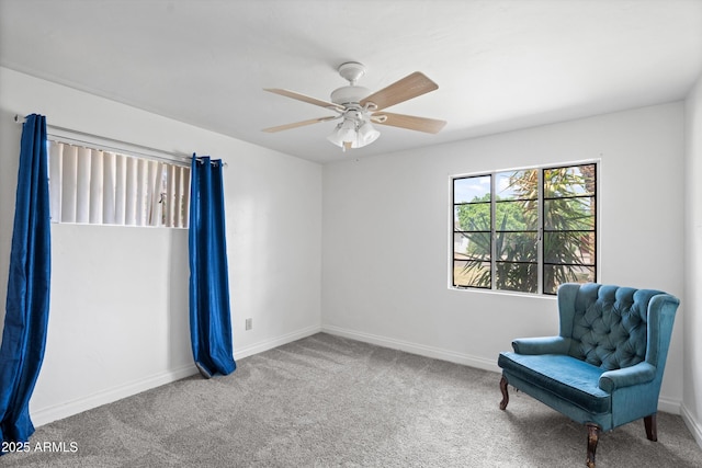 living area featuring baseboards, a ceiling fan, and carpet floors