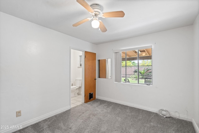 unfurnished bedroom with ensuite bathroom, baseboards, a ceiling fan, and carpet floors