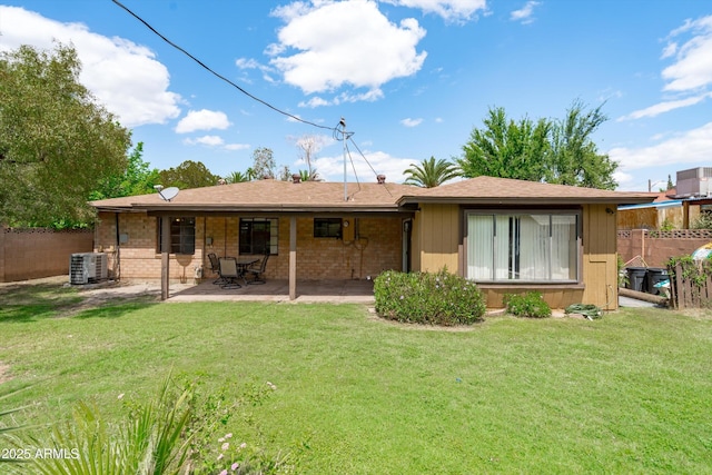 rear view of property with a patio, central air condition unit, a lawn, and fence