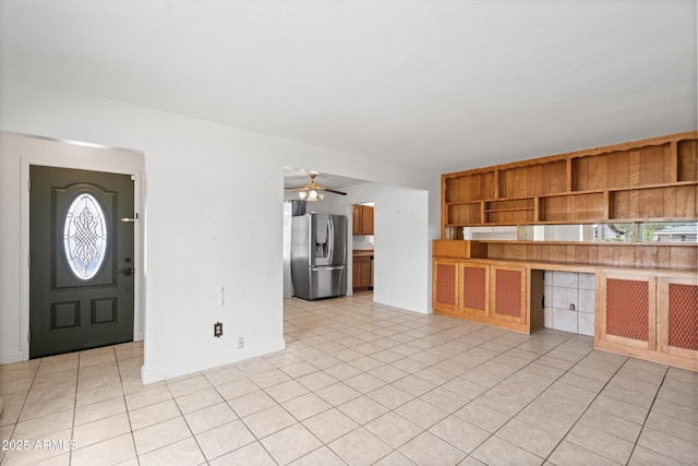 kitchen with brown cabinets, ceiling fan, open shelves, stainless steel refrigerator with ice dispenser, and baseboards