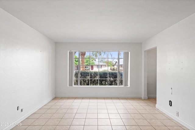 unfurnished room featuring baseboards and light tile patterned flooring