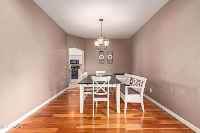 dining room featuring hardwood / wood-style flooring and an inviting chandelier